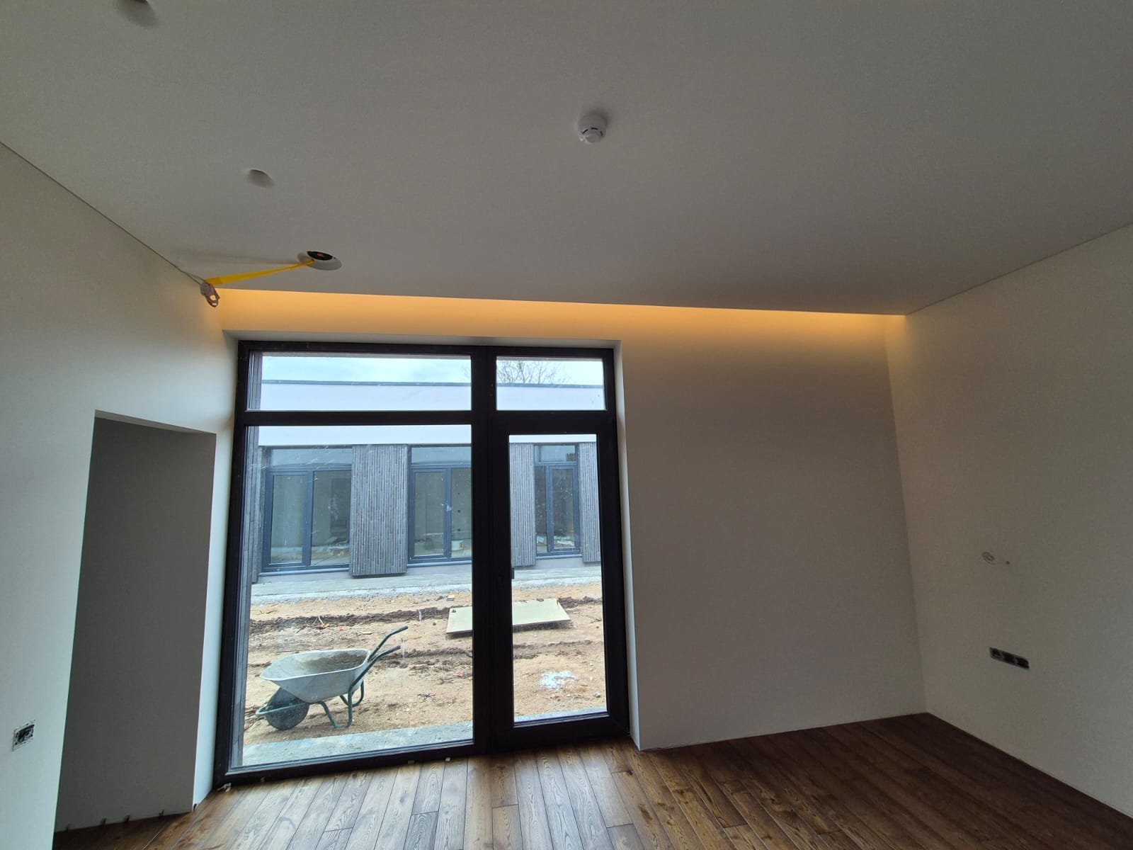 Paslėptas LED juostos apšvietimas lubose prie panoraminio lango